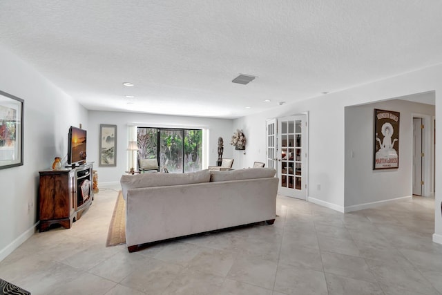 living room with a textured ceiling and french doors