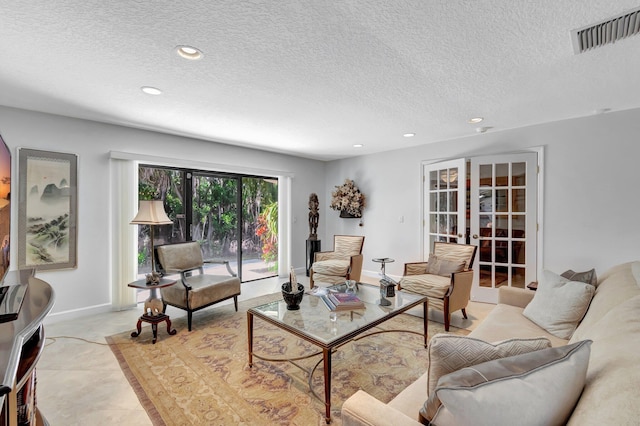 tiled living room with french doors and a textured ceiling