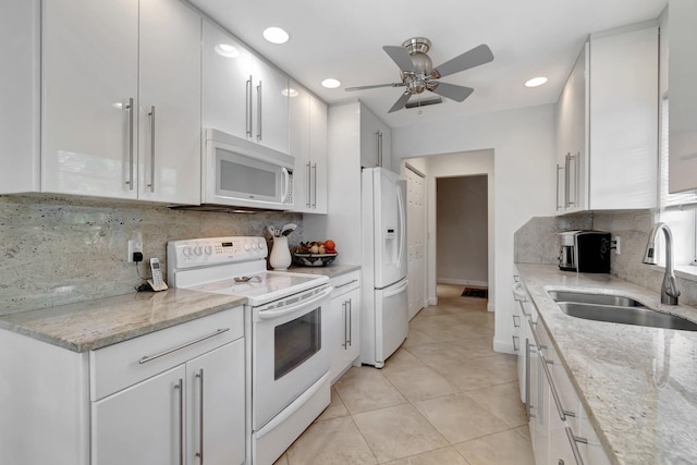 kitchen featuring white cabinetry, sink, light stone counters, and white appliances