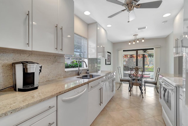 kitchen featuring backsplash, light stone counters, white appliances, sink, and white cabinets