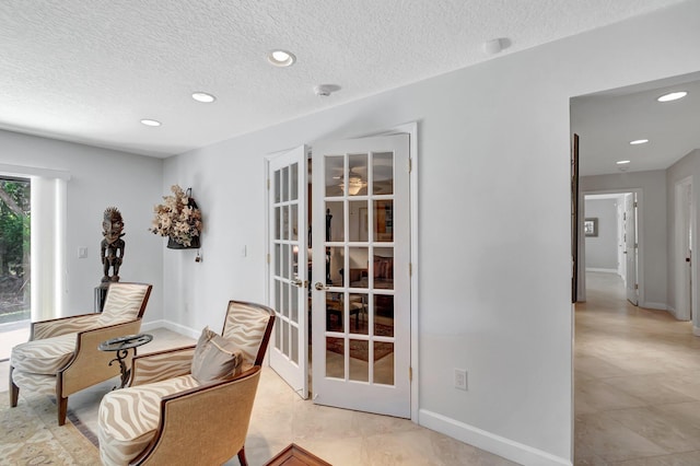 sitting room with a textured ceiling and french doors