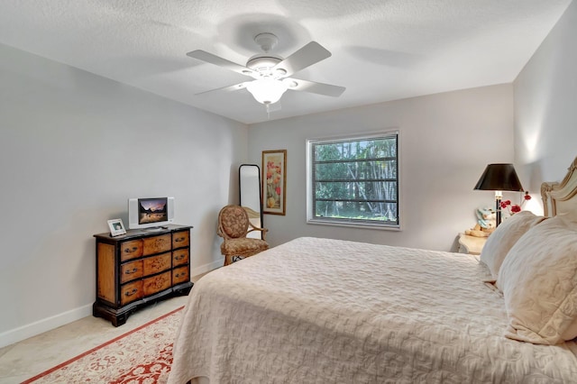 bedroom with ceiling fan and a textured ceiling