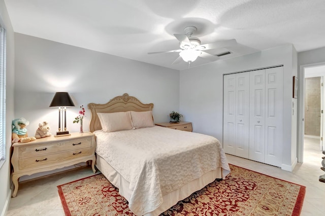 tiled bedroom featuring ceiling fan, a closet, and a textured ceiling