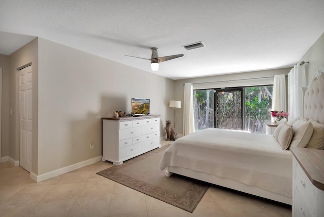 bedroom featuring light tile patterned floors, a textured ceiling, and ceiling fan