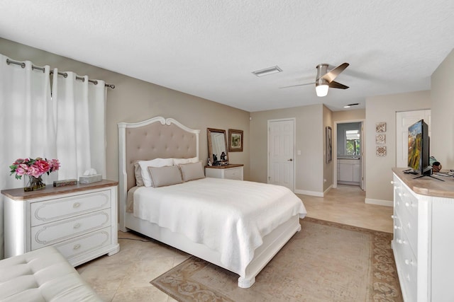 bedroom featuring a textured ceiling, ceiling fan, and light tile patterned flooring