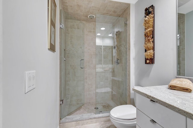 bathroom with vanity, a shower with shower door, and toilet