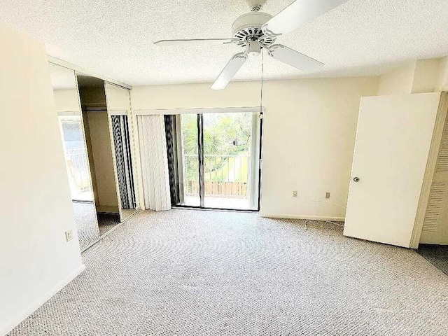 carpeted empty room with a textured ceiling and ceiling fan