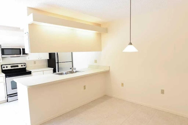 kitchen featuring white cabinetry, sink, kitchen peninsula, decorative light fixtures, and appliances with stainless steel finishes