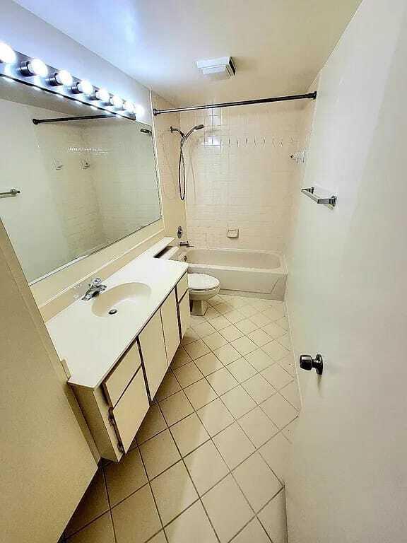 full bathroom with tile patterned flooring, vanity, toilet, and tiled shower / bath