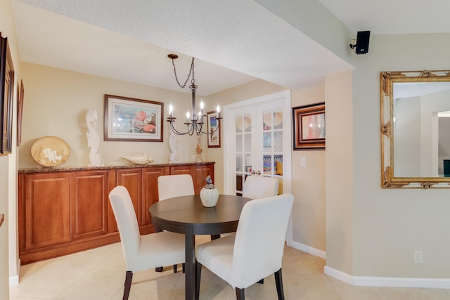 tiled dining space featuring a textured ceiling and an inviting chandelier