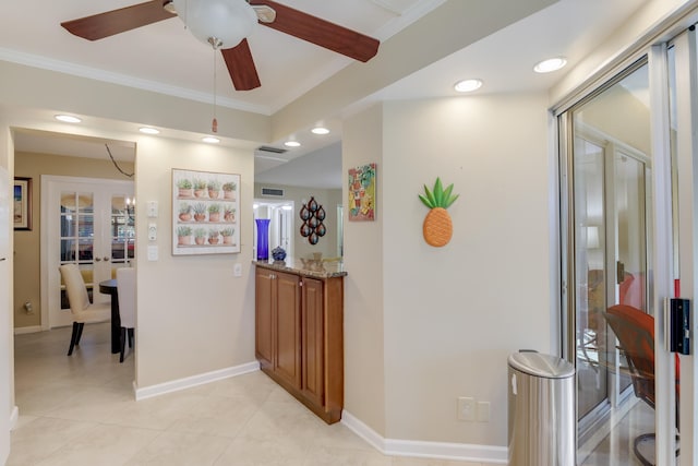 corridor featuring ornamental molding, light tile patterned floors, and french doors