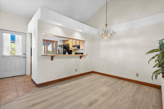 interior space with lofted ceiling, recessed lighting, light wood-type flooring, and baseboards