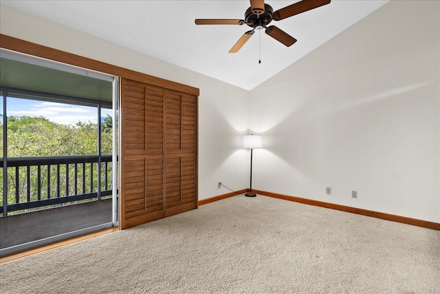 spare room featuring lofted ceiling, carpet flooring, ceiling fan, and baseboards