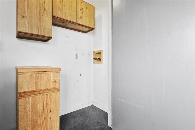 clothes washing area featuring cabinet space and baseboards