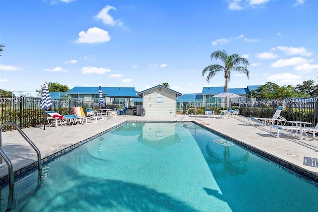 community pool featuring fence and a patio