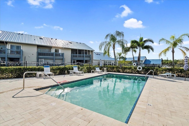 pool with a patio area and fence