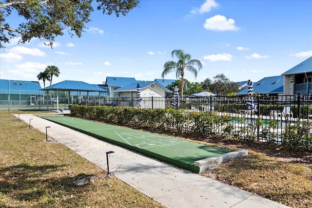 surrounding community with shuffleboard and fence