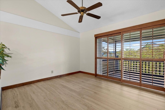 unfurnished room with baseboards, a ceiling fan, lofted ceiling, a textured ceiling, and light wood-type flooring