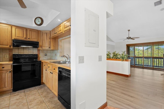 kitchen featuring under cabinet range hood, a sink, visible vents, decorative backsplash, and black appliances