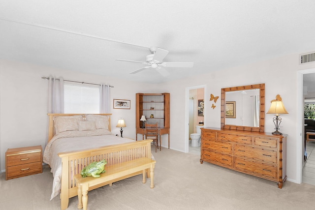 carpeted bedroom with ensuite bathroom, ceiling fan, and a textured ceiling