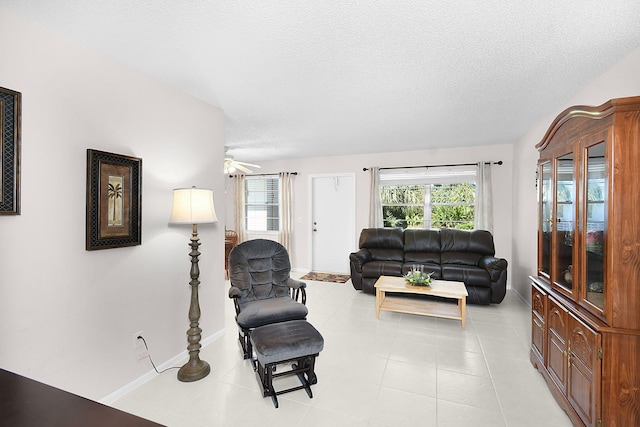 living room featuring a textured ceiling and ceiling fan