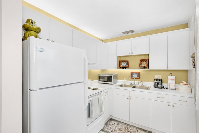 kitchen with white appliances, white cabinetry, and sink