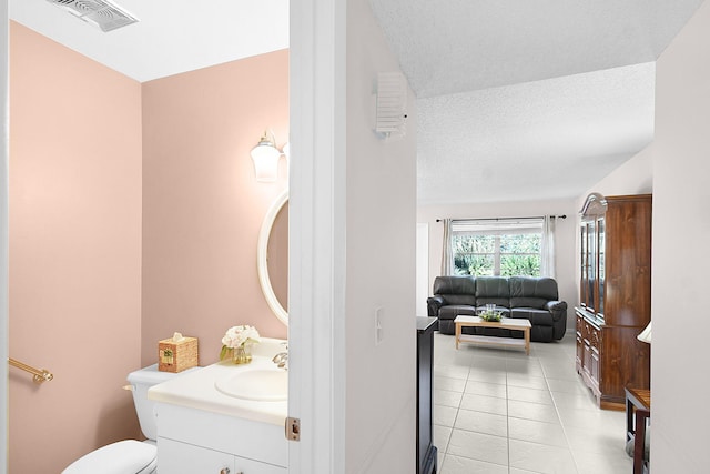 bathroom with vanity, tile patterned floors, a textured ceiling, and toilet