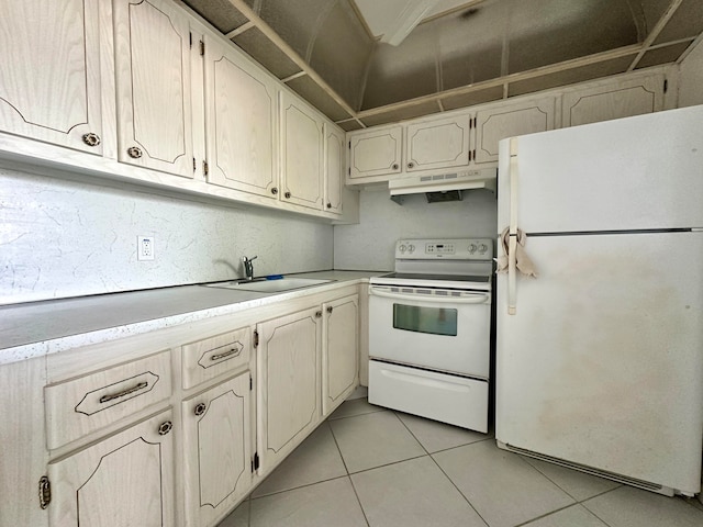 kitchen featuring light tile patterned flooring, white appliances, and sink