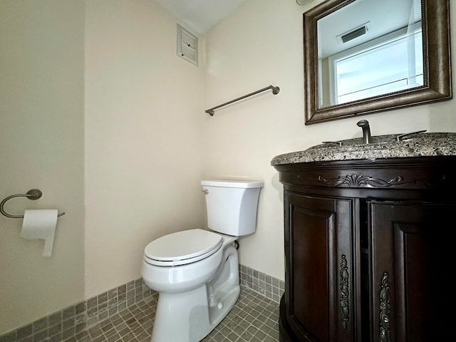 bathroom with tile patterned flooring, vanity, and toilet