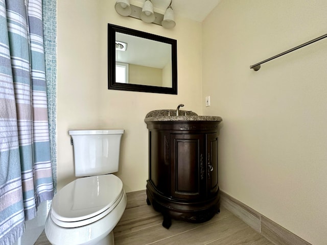 bathroom featuring wood-type flooring, vanity, and toilet