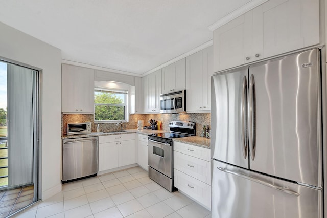 kitchen featuring sink, crown molding, stainless steel appliances, light stone counters, and white cabinets