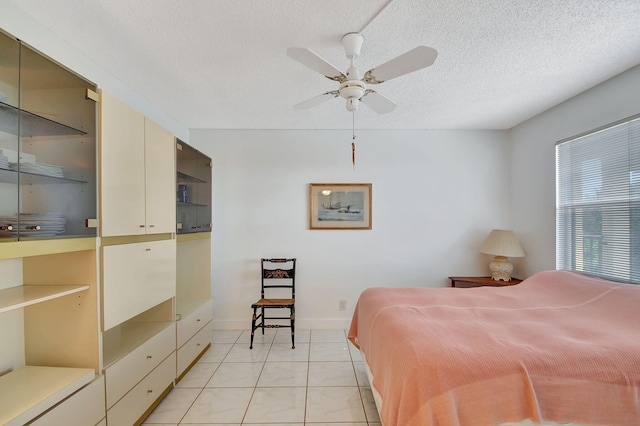 tiled bedroom featuring ceiling fan and a textured ceiling