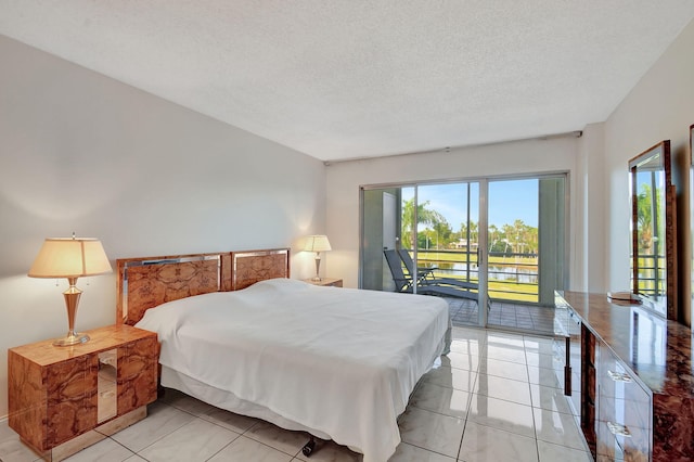 bedroom with access to exterior, a textured ceiling, and light tile patterned flooring