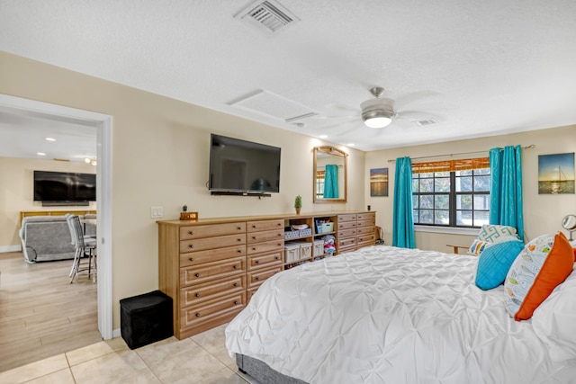 tiled bedroom featuring a textured ceiling and ceiling fan