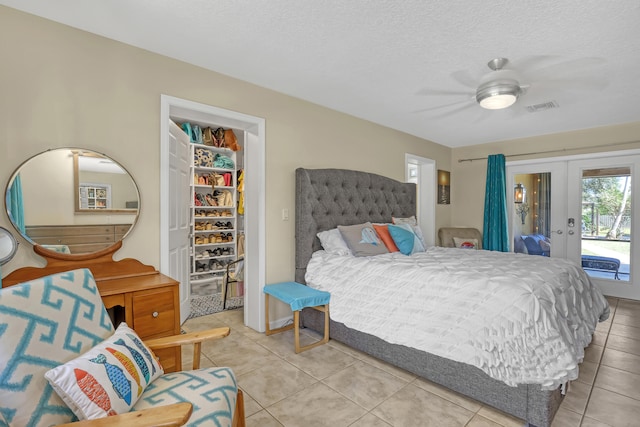 tiled bedroom featuring ceiling fan, french doors, access to outside, and a textured ceiling