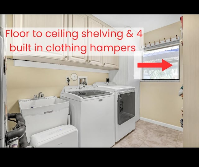 clothes washing area with cabinets, separate washer and dryer, and sink