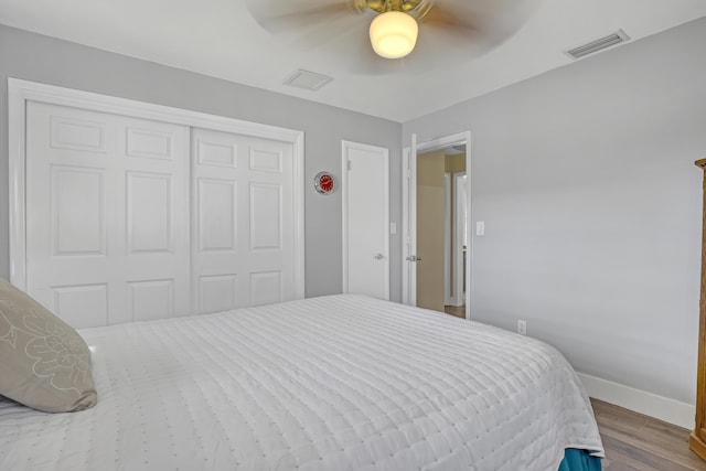 bedroom with ceiling fan, hardwood / wood-style flooring, and a closet