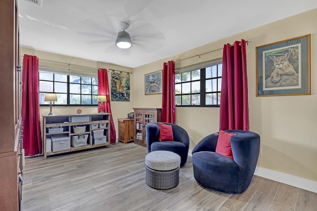 sitting room with ceiling fan, a healthy amount of sunlight, and light wood-type flooring