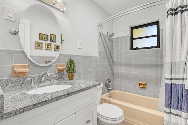 full bathroom with tile walls, toilet, vanity, and shower / bath combination with curtain