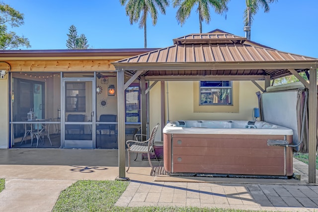 view of front facade with a gazebo, a hot tub, a sunroom, and a patio