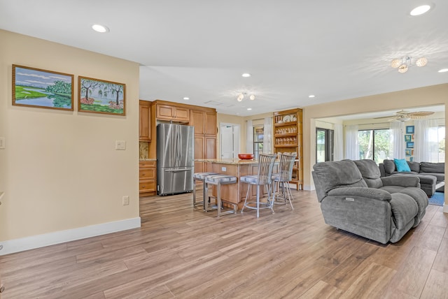 living room featuring ceiling fan and light hardwood / wood-style flooring