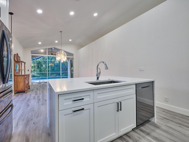 kitchen with white cabinets, sink, vaulted ceiling, stainless steel dishwasher, and decorative light fixtures