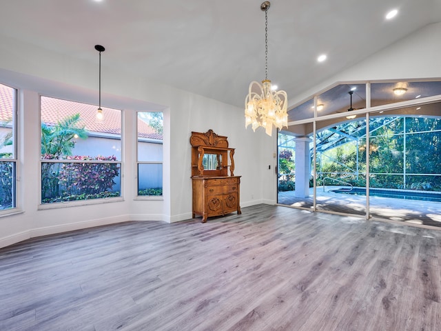 interior space with an inviting chandelier, hardwood / wood-style flooring, and vaulted ceiling