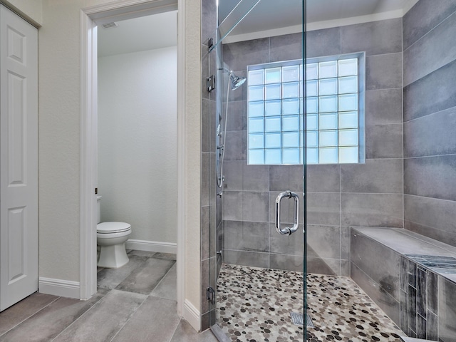 bathroom with toilet and a shower with shower door