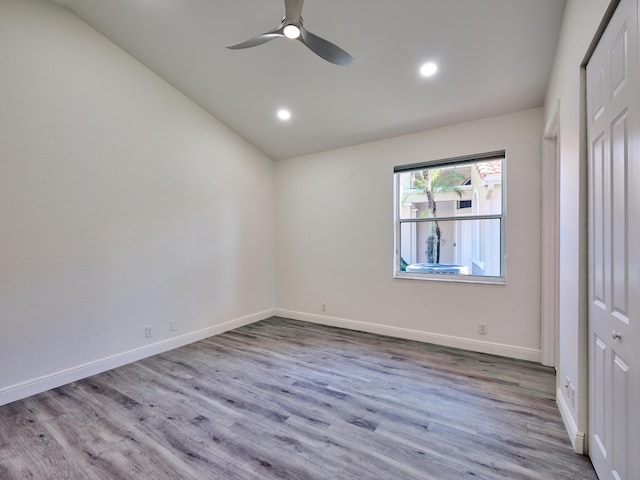 unfurnished bedroom featuring ceiling fan, light hardwood / wood-style flooring, and vaulted ceiling