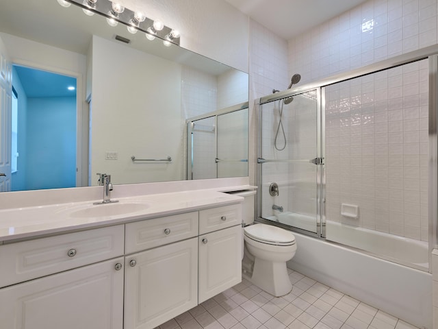 full bathroom featuring tile patterned floors, vanity, bath / shower combo with glass door, and toilet