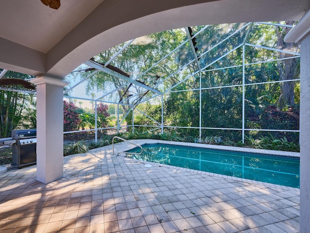 view of swimming pool featuring area for grilling, a patio, and glass enclosure