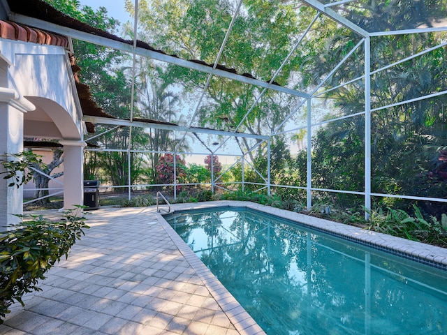 view of swimming pool featuring a lanai and a patio