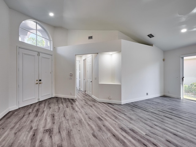 entryway with high vaulted ceiling and light hardwood / wood-style flooring