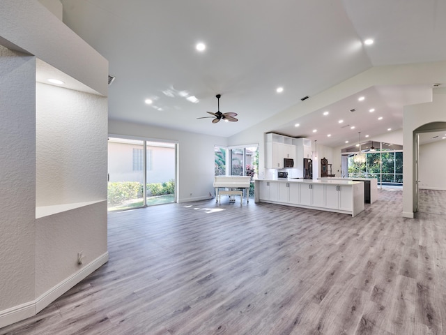 unfurnished living room with ceiling fan, light wood-type flooring, and lofted ceiling